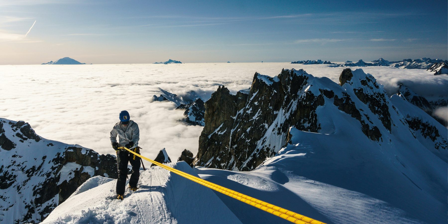Alpiniste seul sur une arête au-dessus des nuages